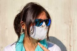 Britse Covid-19 variant - dame met zonnebril en mondmasker