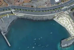 Luchtfoto van kustlijn nieuwe zwemzone van Santa Cruz en jachthaven.