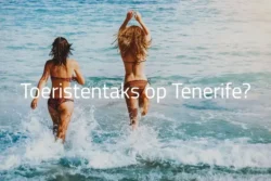 Tenerife overweegt Toeristentaks - Vrouwen rennen in zee op Tenerife strand.