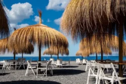 Record toerisme Canarische eilanden - strand met stoeltjes en raffia parasols